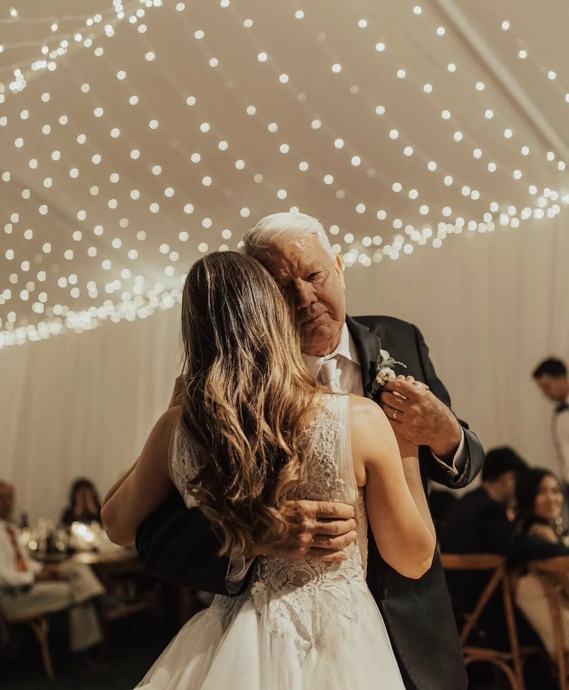Bride sharing a slow dance under a canopy of string lights