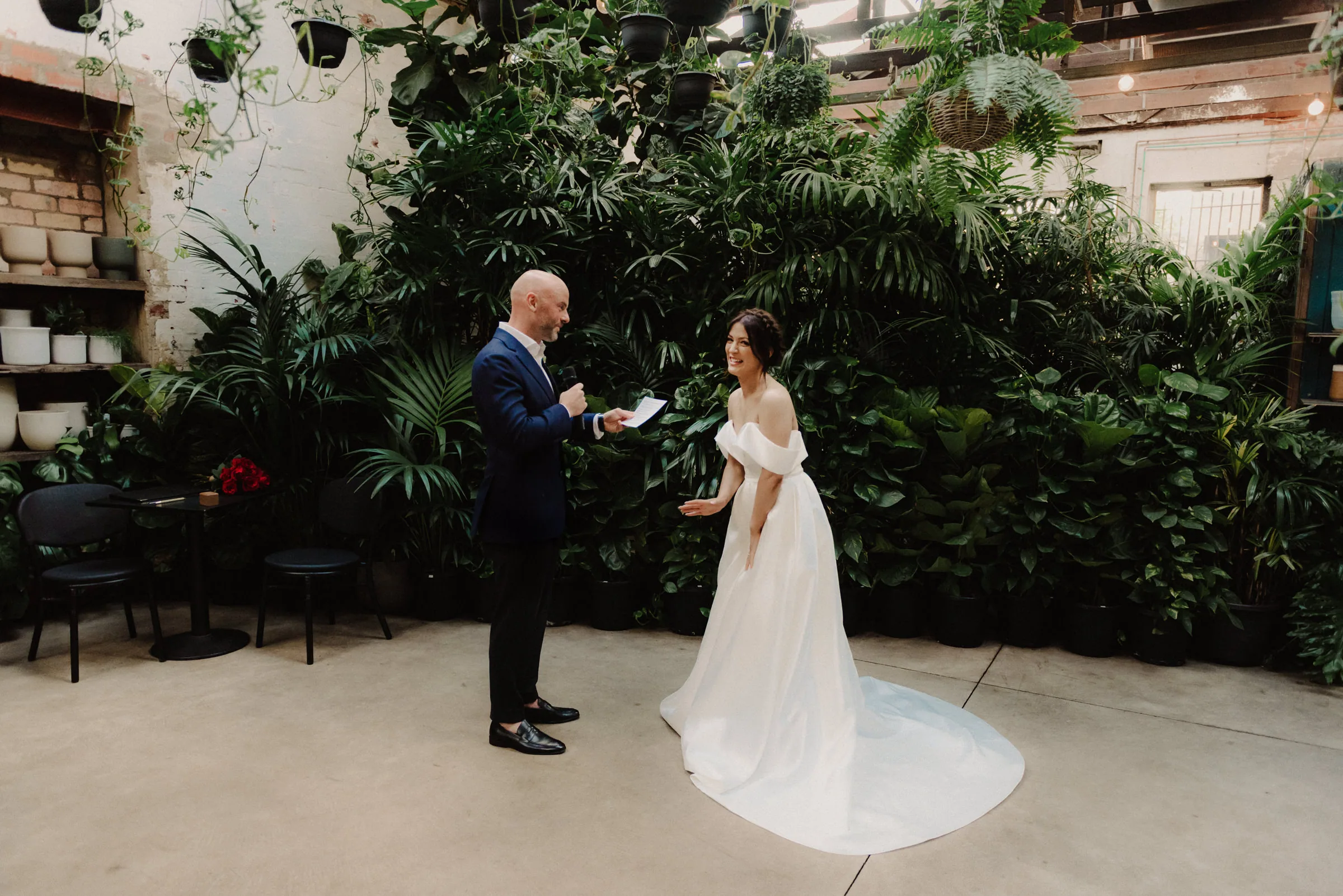 Bride walking down a courtyard aisle on the arm of an older man