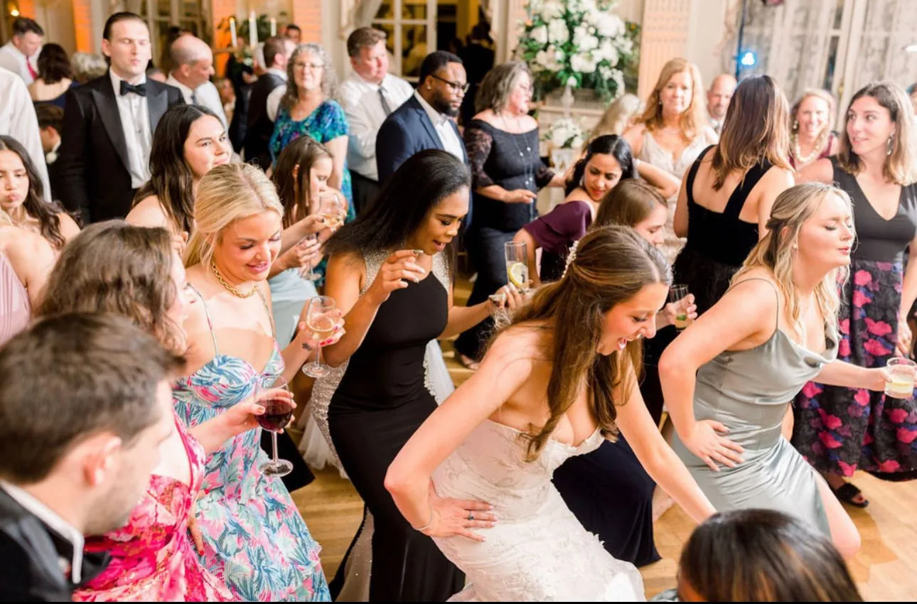 Full dance floor of guests mid-song at a ballroom reception